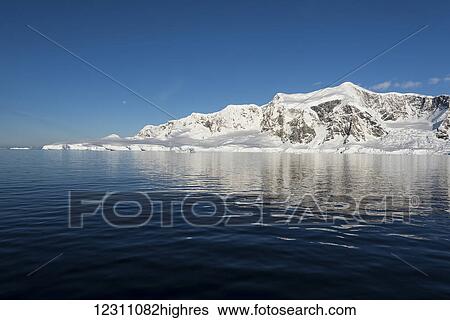 Stock Photograph - Blue sky and snow covered landscape of Wilhelmina Bay; Antarctica. Fotosearch