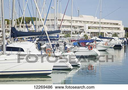 Boats in the harbour reflected in the water View Large Photo Image Stock Photograph - Boats in the harbour reflected in the water. Fotosearch
