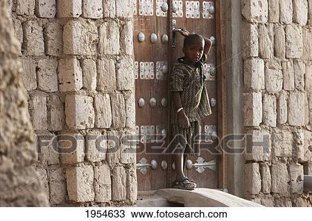 Stock Image - Boy standing at door in Timbuktu, Mali. Fotosearch