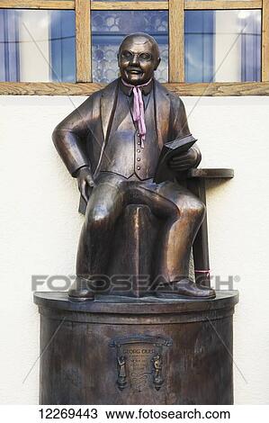 Bronze statue of a man sitting and holding a book; Bayern, Germany View Large Photo Image Stock Image - Bronze statue of a man sitting and holding a book; Bayern, Germany. Fotosearch