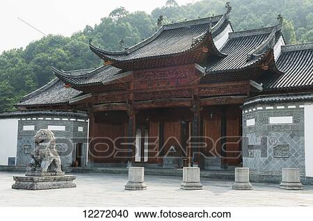 Stock Image - Building of traditional chinese architecture and a lion statue in a small village near Wuyuan; Jiangxi province, China. Fotosearch