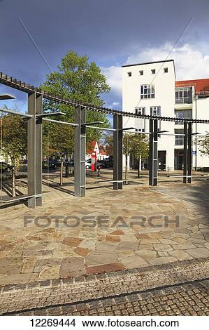 Picture - Buildings and a metal structure creating a boundary in an urban area; Gilching, Bayern, Germany. Fotosearch