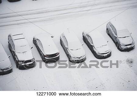 Stock Image - Cars covered in snow in downtown parking lot; Toronto, Ontario, Canada. Fotosearch