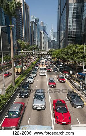 Stock Photograph - Central district in Hong Kong Island, red taxis and traffic; Hong Kong, China. Fotosearch