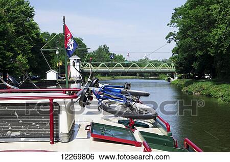 Charter boat heads towards Adam Street bridge; Spencerport, New York, United States of America View Large Photo Image Stock Photograph - Charter boat heads towards Adam Street bridge; Spencerport, New York, United States of America. Fotosearch