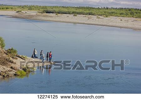 Stock Photography - Children from Noatak Village fishing with fishing poles on the banks of the Noatak River, Noatak, Arctic Alaska, USA, Summer. Fotosearch