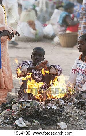 Children warm up by a fire at the Monday Market, Djenne, Mali View Large Photo Image Stock Photograph - Children warm up by a fire at the Monday Market, Djenne, Mali. Fotosearch