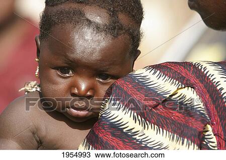 Stock Image - Close-up of a baby with mother in Bamako, Mali. Fotosearch