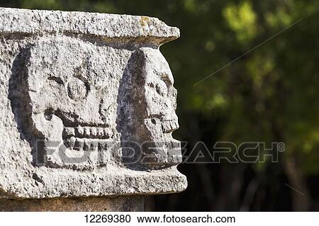 Close up of Ancient Mayan rock carvings of skulls on edge of building with trees in background; Chichen Itza, Yucatan, Mexico View Large Photo Image Stock Image - Close up of Ancient Mayan rock carvings of skulls on edge of building with trees in background; Chichen Itza, Yucatan, Mexico. Fotosearch
