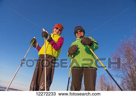 Stock Image - Close up of two people cross country skiing on the Tony Knowles Coastal Trail, Southcentral Alaska. Fotosearch