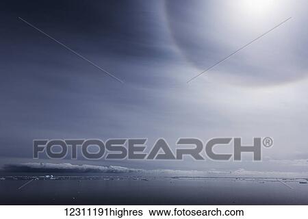 Stock Photograph - Cloud formation over the horizon and ocean viewed from the beach; Antarctica. Fotosearch