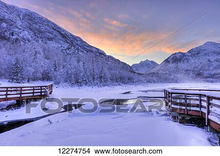 Colorful sunrise over a stream and the salmon viewing deck at the Eagle River Nature Center in Chugach State Park, Southcentral Alaska, Winter, HDR View Large Photo Image Picture - Colorful sunrise over a stream and the salmon viewing deck at the Eagle River Nature Center in Chugach State Park, Southcentral Alaska, Winter, HDR. Fotosearch