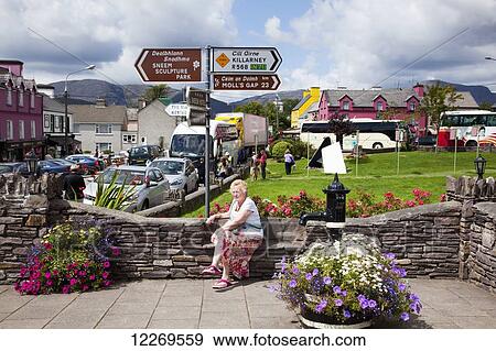 Stock Photo - Colourful buildings and flowers decorate an urban area; Sneem, County Kerry, Ireland. Fotosearch
