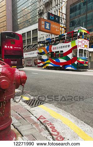 Stock Image - Colourful double decker bus in the road, Central District; Hong Kong Island, China. Fotosearch