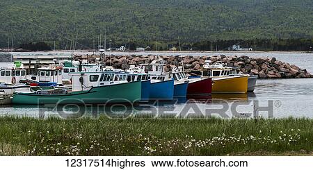 Stock Photograph - Colourful fishing boats moored in a row in a harbour; Cape Breton, Nova Scotia, Canada. Fotosearch