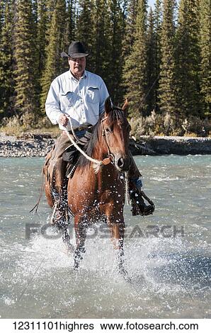 Cowboy and horse crossing river, Clearwater county; Alberta, Canada View Large Photo Image Stock Photograph - Cowboy and horse crossing river, Clearwater county; Alberta, Canada. Fotosearch