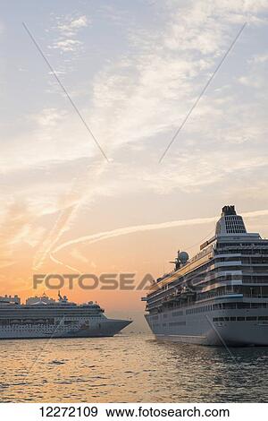 Stock Photo - Cruise ships in the harbour at sunset, Kowloon; Hong Kong, China. Fotosearch