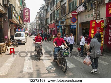 Cyclists and pedestrians at the traditional street market; Xiamen, Fujian province, China View Large Photo Image Stock Photo - Cyclists and pedestrians at the traditional street market; Xiamen, Fujian province, China. Fotosearch