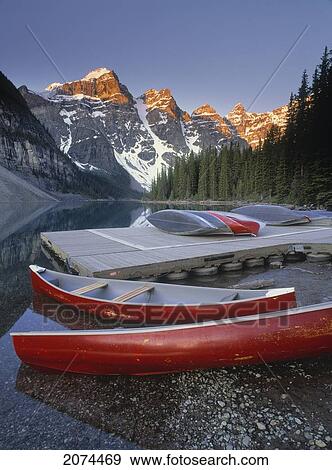 Stock Photo - D. Wiggett; Canoes Docked, Moraine Lake, Valley, Ten Peaks, Banff Np, Ab. Fotosearch