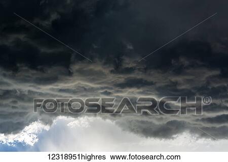Stock Photograph - Dramatic dark storm cloud front with rain coming down; Calgary, Alberta, Canada. Fotosearch