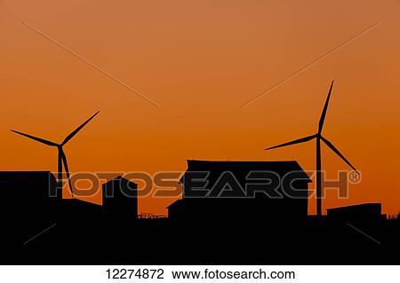 Stock Image - Elk Wind Energy Farm and barn silhouette at sunrise, near Edgewood; Iowa, United States of America. Fotosearch