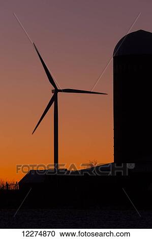 Stock Image - Elk Wind Energy Farm and silo at sunrise, near Edgewood; Iowa, United States of America. Fotosearch