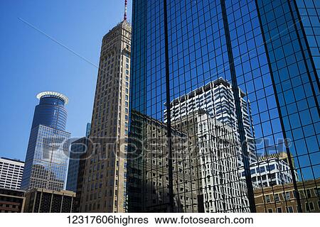 Facade of a skyscraper with windows reflecting the blue sky and buildings; Minneapolis, Minnesota, United States of America View Large Photo Image Stock Photograph - Facade of a skyscraper with windows reflecting the blue sky and buildings; Minneapolis, Minnesota, United States of America. Fotosearch