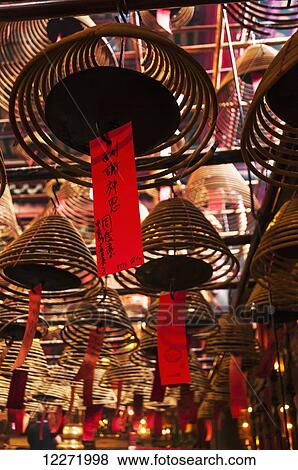 Stock Photo - Famous Man Mo Buddhist temple with spectacular incenses hanging from ceiling; Hong Kong, China. Fotosearch