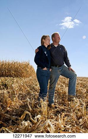 Farmer husband and wife pose together in a partially harvested grain corn field in Autumn, near Sioux City; Iowa, United States of America View Large Photo Image Stock Photo - Farmer husband and wife pose together in a partially harvested grain corn field in Autumn, near Sioux City; Iowa, United States of America. Fotosearch