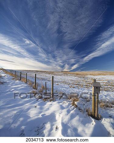 Stock Image - Fence With Bird House And Stubble Field In Winter Near Water Valley, Alberta. Fotosearch