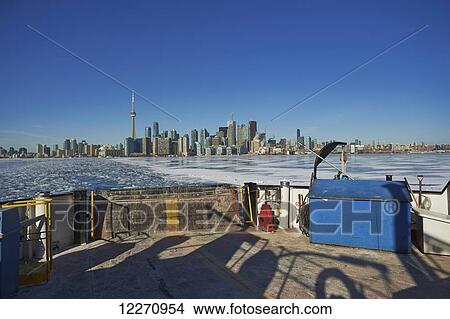 Picture - Ferry moving threw breaking ice in harbor waterfront; Toronto, Ontario, Canada. Fotosearch