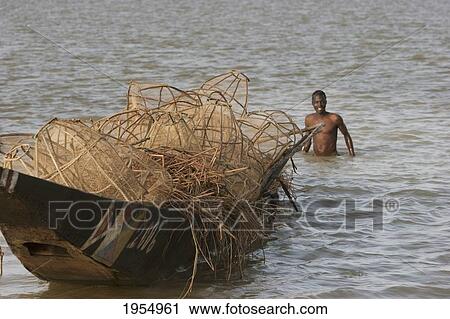 Stock Image - Fisherman and nets on a boat in Lake Debo, Niger River, Mali. Fotosearch