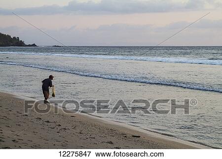Fisherman casting his net in the ocean, Mangsit, Lombok, West Nusa Tenggara, Indonesia View Large Photo Image Stock Photo - Fisherman casting his net in the ocean, Mangsit, Lombok, West Nusa Tenggara, Indonesia. Fotosearch