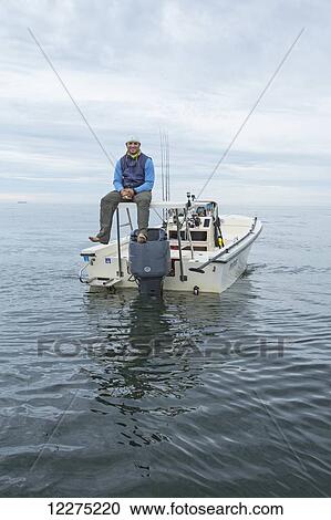 Fisherman sitting on his boat on the tranquil ocean water, Boston harbour; Boston, Massachusetts, United States of America View Large Photo Image Stock Image - Fisherman sitting on his boat on the tranquil ocean water, Boston harbour; Boston, Massachusetts, United States of America. Fotosearch