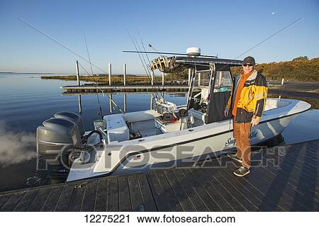 Fisherman standing on a dock beside his boat; Montauk, New York, United States of America View Large Photo Image Stock Image - Fisherman standing on a dock beside his boat; Montauk, New York, United States of America. Fotosearch