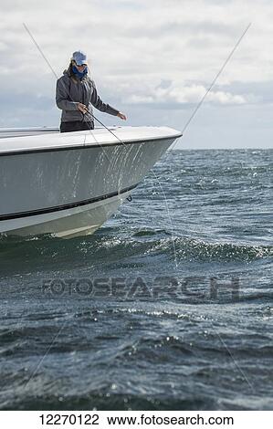 Stock Image - Fishing off a boat in the tranquil Atlantic ocean; Martha's Vineyard, Massachusetts, United States of America. Fotosearch