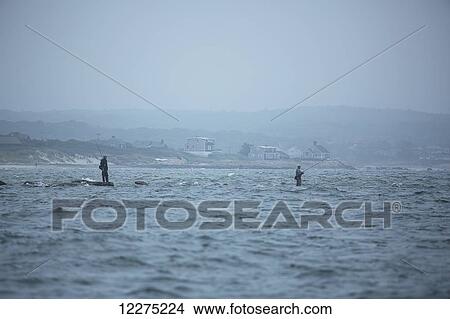 Picture - Fishing on the rocks in the water along the coast; Cape Cod, Massachusetts, United States of America. Fotosearch