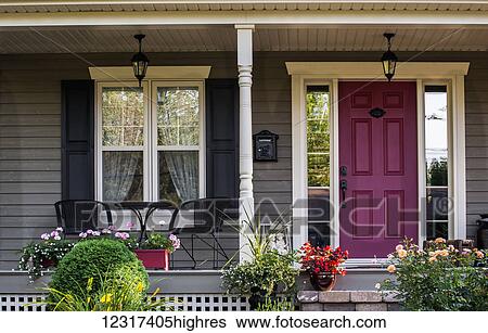 Front porch of a house with decorative plants and flowers and a red door; Knowlton, Quebec, Canada View Large Photo Image Stock Photograph - Front porch of a house with decorative plants and flowers and a red door; Knowlton, Quebec, Canada. Fotosearch