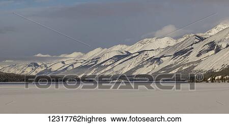 Stock Photograph - Frozen Muncho Lake in winter, Muncho Lake Provincial Park; British Columbia, Canada. Fotosearch