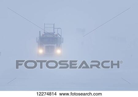 Picture - Fuel truck driving in blizzard conditions in the Prudhoe Bay Oil Field, North Slope, Arctic Alaska, Winter. Fotosearch