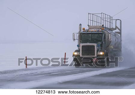 Stock Image - Fuel truck driving in blizzard conditions in the Prudhoe Bay Oil Field, North Slope, Arctic Alaska, Winter. Fotosearch