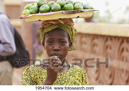 Picture - Girl carrying fruits on her head in Segou, Mali. Fotosearch