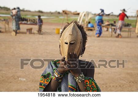 Stock Photo - Girl playing with a mask near the Bani River, Mali. Fotosearch