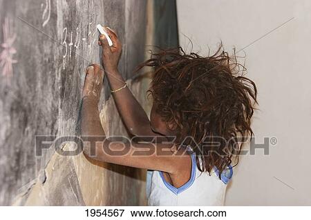 Girl writing on a blackboard at a primary school in Tiriken, Mali View Large Photo Image Stock Photo - Girl writing on a blackboard at a primary school in Tiriken, Mali. Fotosearch