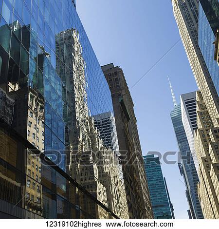 Glass facade of a skyscraper reflecting other skyscrapers; New York City, New York, United States of America View Large Photo Image Stock Photograph - Glass facade of a skyscraper reflecting other skyscrapers; New York City, New York, United States of America. Fotosearch