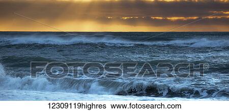 Stock Photograph - Golden sunset over a west coast sea; Greymouth, South Island, New Zealand. Fotosearch