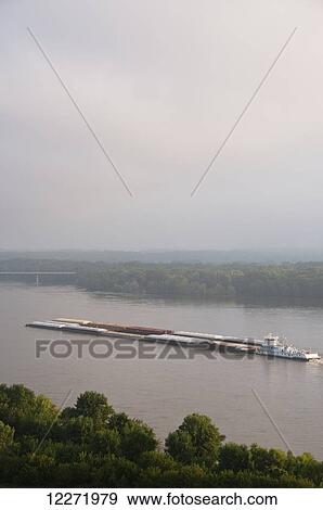 Grain barge navigating the Mississippi River early on an overcast morning, near Hannibal; Missouri, United States of America View Large Photo Image Stock Photo - Grain barge navigating the Mississippi River early on an overcast morning, near Hannibal; Missouri, United States of America. Fotosearch