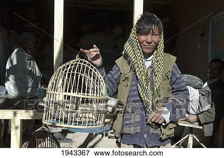 Hazara Man Holding A Bird Cage At The Bazaar In Bamiyan, Bamian Province, Afghanistan View Large Photo Image Stock Photo - Hazara Man Holding A Bird Cage At The Bazaar In Bamiyan, Bamian Province, Afghanistan. Fotosearch