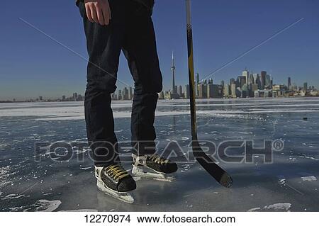 Picture - Hockey player and city skyline from Ward's Island; Toronto, Ontario, Canada. Fotosearch