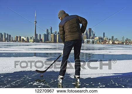 Hockey player and city skyline from Ward's Island; Toronto, Ontario, Canada View Large Photo Image Stock Photo - Hockey player and city skyline from Ward's Island; Toronto, Ontario, Canada. Fotosearch